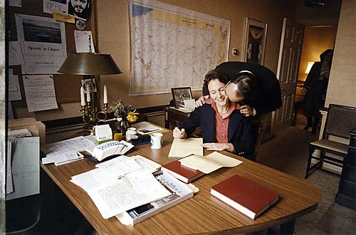 Ginny Thornburgh at her desk receives a kiss from the Governor