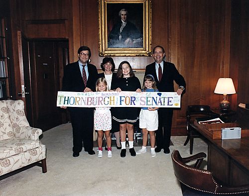 Bill Barr and family with Thornburgh at farewell reception, holding "Thornburgh for Senate" sign