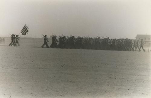 Soldiers with Rifles Followed By the Flag