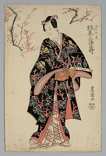 Full-length portrait of the actor Bando Mitsugoro III standing under a flowering cherry tree holding a pipe