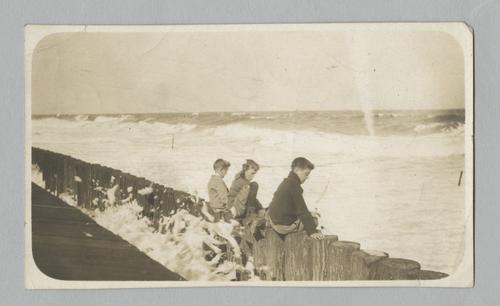 Rinehart sons as boys on pilings at the shore