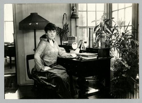 Mary Roberts Rinehart seated at desk