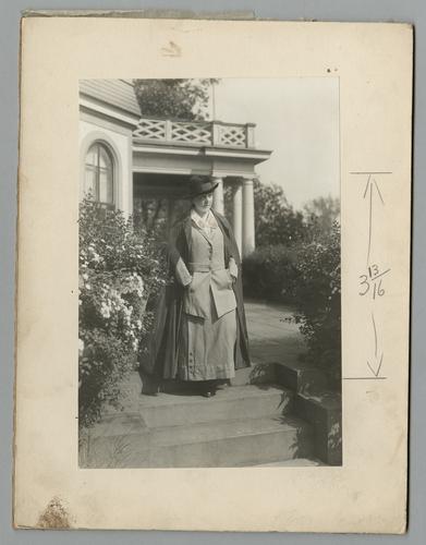 Mary Roberts Rinehart portrait on garden steps, in hat and coat