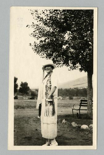 Mary Roberts Rinehart outdoors in white dress and hat, with scarf