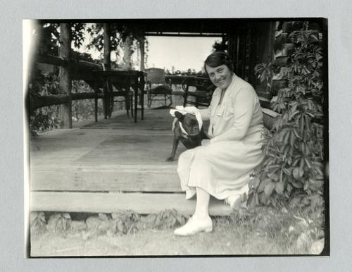 Mary Roberts Rinehart on porch with bandaged dog